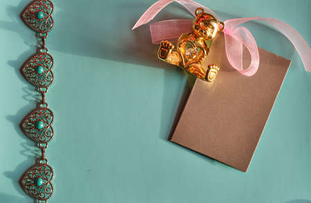Concept for valentine's day. Ð¡hain of metal hearts, a Valentine card and a golden, holding a heart, metal bear on a light background with space for text or logo.の写真素材