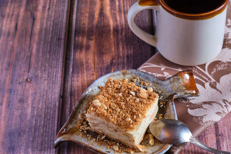 Homemade baked cake Napoleon, Millefeuille. Delicate custard cake. Against the background of a wooden table with a beautiful napkin.の写真素材