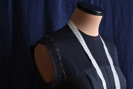 Semi-ready blue dress with tailor's measuring tape on mannequin