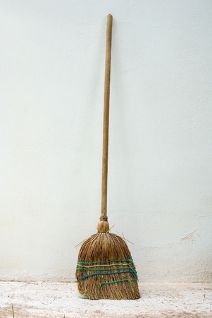 old classic wooden straw Broomstick against wall outdoorの写真素材