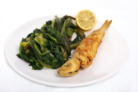 fried fish with lemonand vegetables in white dishの写真素材