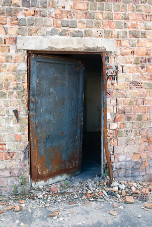 Metal door in abandoned brick industry buildingの写真素材