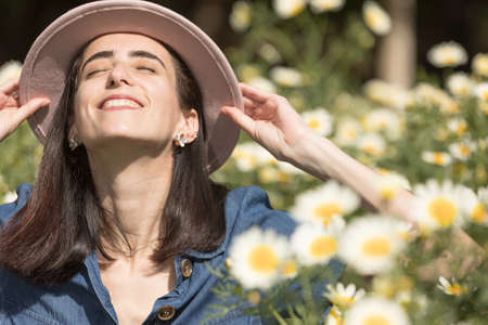 Smiling young woman holding her pink hat