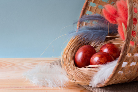 The easter background with Easter eggs, colored an onions peel, in a basket on a wooden background...