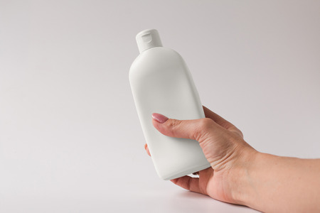 White plastic bottle for cream on a grey background. Front view. The place for the textの写真素材