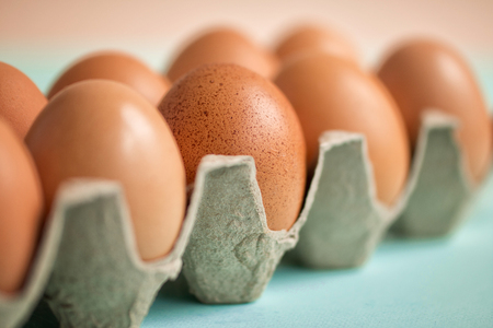 Brown eggs in cardboard packing. Ecological packing. Happy Easter. Selective focus.  Front viewの写真素材