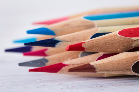 Colored wooden pencils on a white wooden table. Macro. Close up.の写真素材