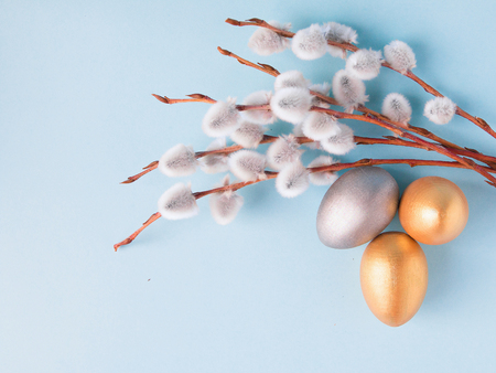 Gold and silver Easter eggs, willow branches on a blue background. Easter concept. National holiday celebration concepts. Happy Easter. Top view. Copy spaceの写真素材