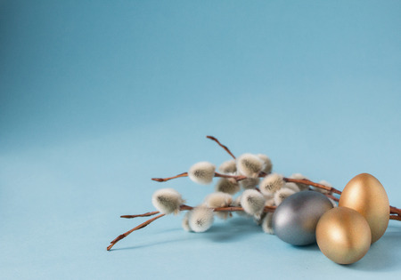 Gold and silver Easter eggs, willow branches on a blue background. Easter concept. National holiday celebration concepts. Happy Easter. Front view. Copy spaceの写真素材