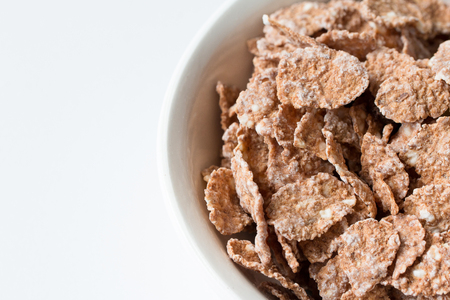 Bowl of multigrain natural flakes  on a white background. Healthy food. Top view.