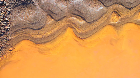 Sand and yellow water. Abstract texture. Colors of the nature. Close up. Top viewの写真素材
