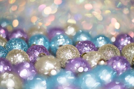 Blurred image of bright violet, blue and gold Christmas toys on sparkle background. Soft focus and beautiful  bokeh. New Years Christmas holiday screensaver, background.の写真素材