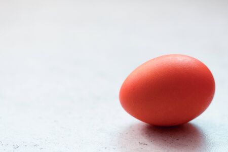 Red easter egg on grey concrete table. Front view. Selective focus. Easter decoration. Concept of easter religious holiday celebration, traditionsの写真素材