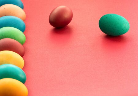 Colorful multi-colored Easter Eggs arranged to one side on a red background. Easter decoration. Easter concept. Copy spaceの写真素材