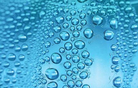 Close up water drops on sky blue tone background. Abstract sky blue wet texture with water drops on glass surface.  Raindrop, realistic pure water droplets, condensate, for creative banner designの写真素材