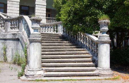 Ancient staircase with stone balusters on a background of green vegetationの写真素材