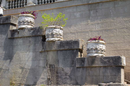 Staircase of an old building made of gray stone with decorative flowerpots in the Parkの写真素材