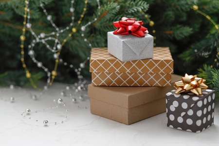 Christmas presents and gift boxes wrapped in kraft paper on a wooden table with golden fir cones, fir-tree branches, and decoration. New Year,Christmas concept.の写真素材