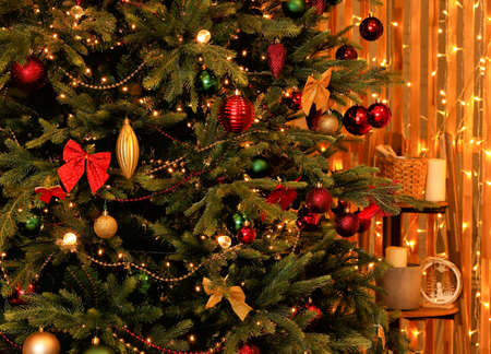 The Christmas tree is decorated with shiny Christmas toys, bows, gold and red garlandsの写真素材