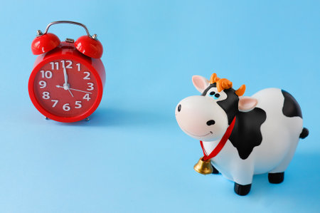 Toy bull on a blue background with a red alarm clock. Symbol of the Chinese New year 2021. Christmas conceptの写真素材
