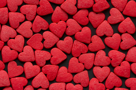 Red Hearts Candy on black surface close up. Valentines day concept. Macro. Sweet red candy textureの写真素材