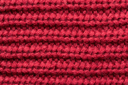Red knitted fabric as an abstract texture. Knitting, elastic band pattern, English elastic band. Close-up.の写真素材