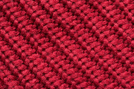 Red knitted fabric as an abstract texture. Knitting, elastic band pattern, English elastic band. Diagonal rows. Close-up.の写真素材