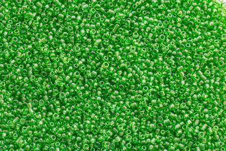 Background texture of green color beads closeup. Seamless beads texture. Hobbies, handmade jewelry, craft. Abstract backgroundの写真素材