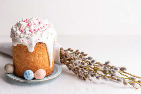 Traditional homemade Easter cake, decorated with glaze and pastry sprinkles on a blue plate on a...