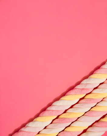 Border of spiral marshmallows on a pink background. Copy space.の写真素材