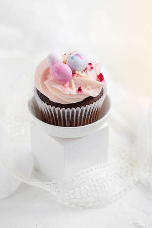Easter chocolate cupcake with caramel filling and decoration in the form of small Easter eggs from marzipanの写真素材