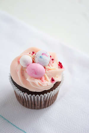 Easter chocolate cupcake with caramel filling and decoration of small Easter eggs from marzipan. Selective focusの写真素材