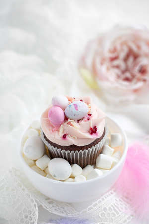 Easter chocolate cupcake with caramel filling and decoration in the form of small Easter eggs from marzipanの写真素材