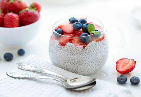 Healthy Chia Pudding with Coconut Milk, strawberries, chia seeds, blueberries in a Glass. Concept of healthy eating, healthy lifestyle, dieting, fitness menu.の写真素材