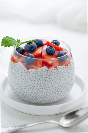 Healthy Chia Pudding with Coconut Milk, strawberries, chia seeds, blueberries in a Glass. Concept of healthy eating, healthy lifestyle, dieting, fitness menu.の写真素材