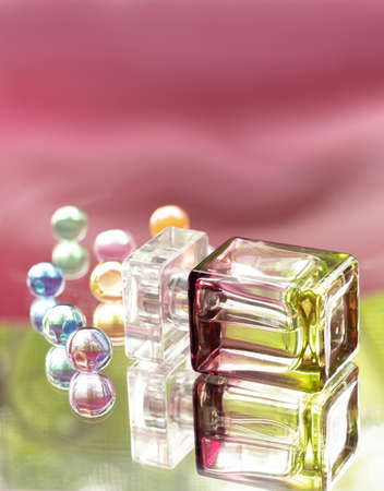Perfume bottle with glass colored balls on a pink background. Perfumes, cosmetics, a collection of fragrances.の写真素材