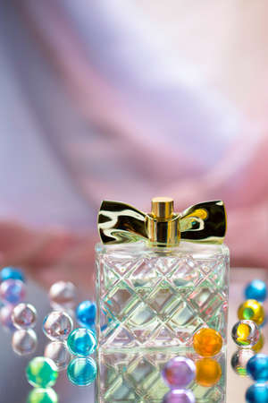 Perfume bottle with glass colored balls on a light background. Perfumes, cosmetics, a collection of fragrances.の写真素材