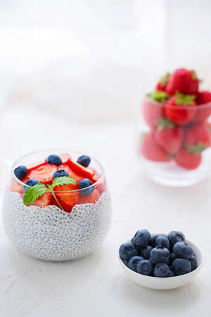 Healthy Chia Pudding with Coconut Milk, strawberries, chia seeds, blueberries in a Glass. Concept of healthy eating, healthy lifestyle, dieting, fitness menu.の写真素材