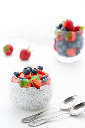 Healthy Chia Pudding with Coconut Milk, strawberries, chia seeds, blueberries in a Glass. Concept of healthy eating, healthy lifestyle, dieting, fitness menu.の写真素材