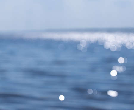 Blurred blue sea with bokeh light. Summer tropical sea with sparkling waves. Landscape of tropical summer.の写真素材