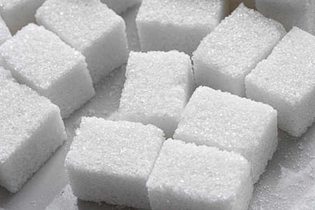 White Refined Sugar on a white porcelain plate. Selective focus, front view. Macroの写真素材