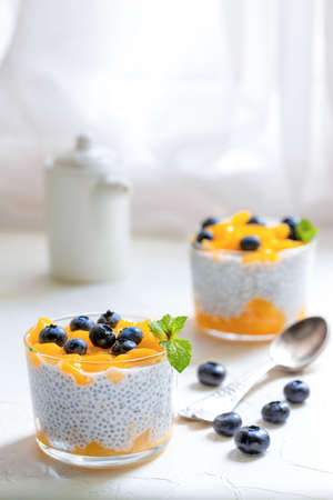 Healthy Chia Pudding with Coconut Milk, mango, chia seeds, blueberries in a Glass. Concept of healthy eating, healthy lifestyle, dieting, fitness menu.の写真素材