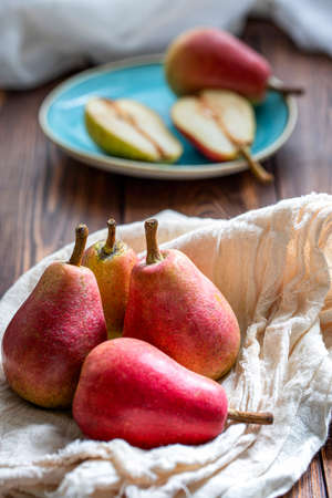 Ripe red pears on a cotton napkin on a wooden table . Close up.の写真素材