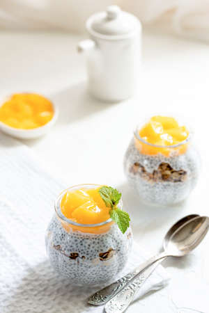 Healthy Chia Pudding with Coconut Milk, mango, chia seeds, granola in a Glass. Concept of healthy eating, healthy lifestyle, dieting, fitness menu.の写真素材