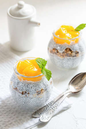 Healthy Chia Pudding with Coconut Milk, mango, chia seeds, granola in a Glass. Concept of healthy eating, healthy lifestyle, dieting, fitness menu.の写真素材