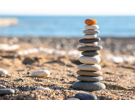 Pyramids of sea pebbles on the beach against the sea on a sunny dayの写真素材