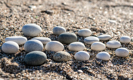 A round pebbles lies in rows on the sand. Front viewの写真素材