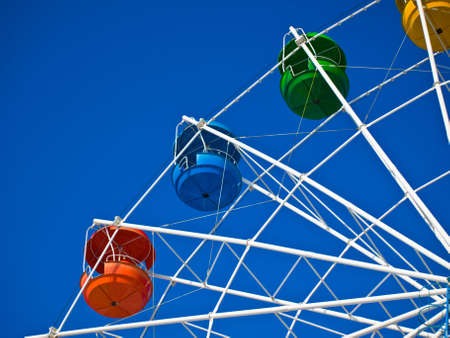 Fragment of wheel reviews with coloured cabins on background of blue skyの写真素材