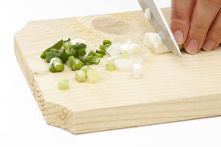 Green spring onions cutting by a vomen hand