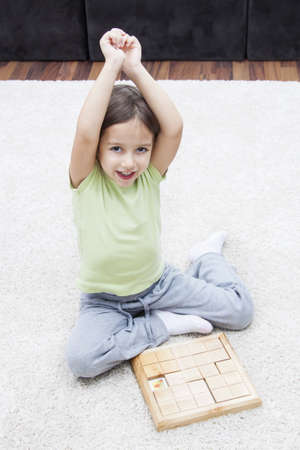 Happy little girl playing on the floorの写真素材